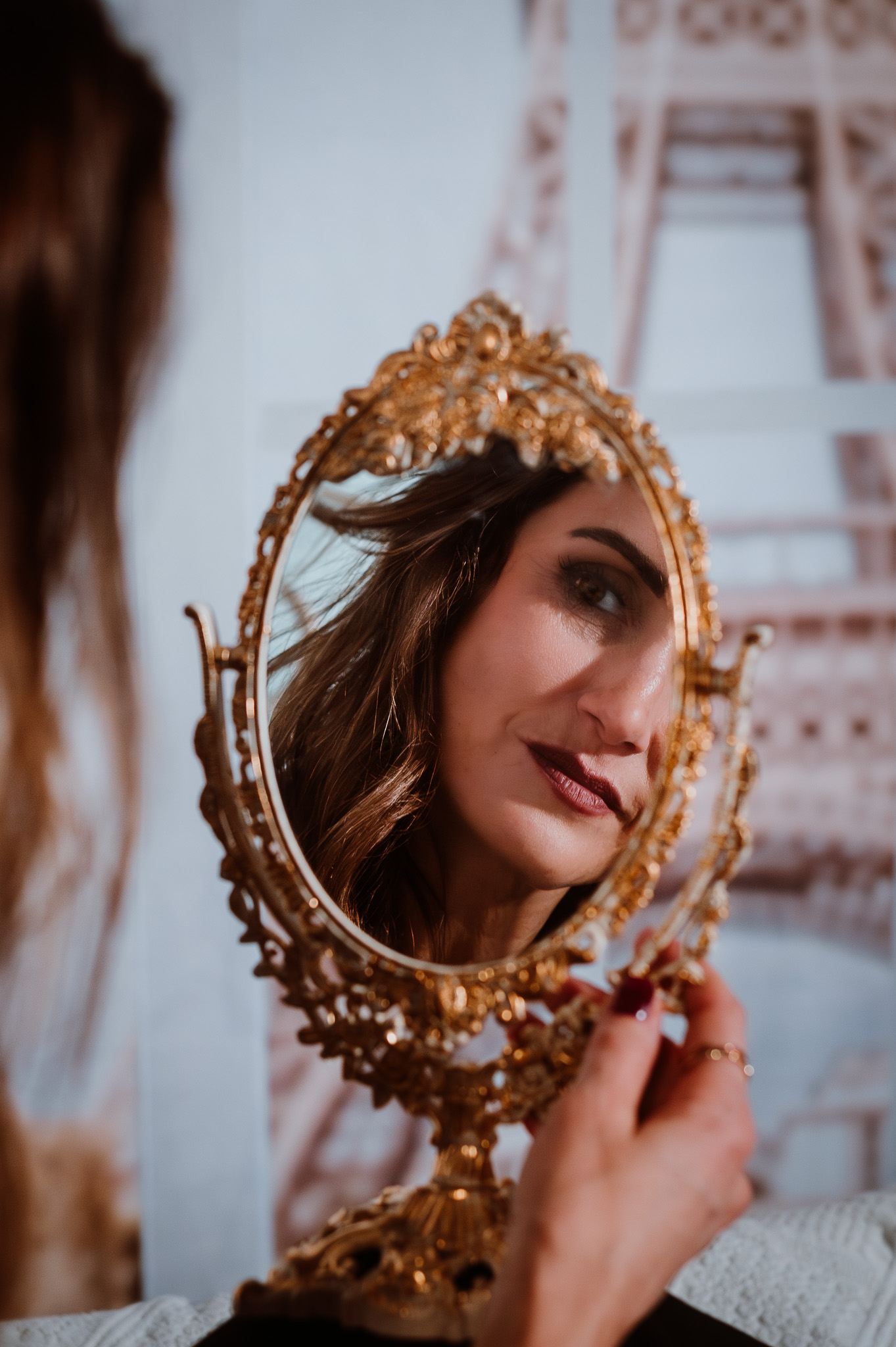 Eine Frau Schaut im Spiegel mit Eiffelturm im Hintergrund